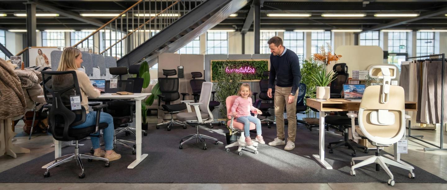 Foto van een showroom met bureaustoelen en kunstplanten.